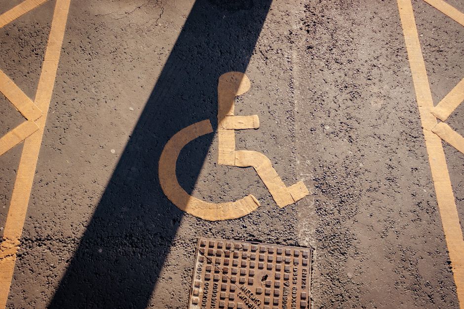 Close-up of a yellow wheelchair symbol painted on asphalt, highlighting accessibility.
