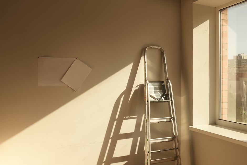 A ladder leans against a sunlit wall next to a window in Kyiv, Ukraine.