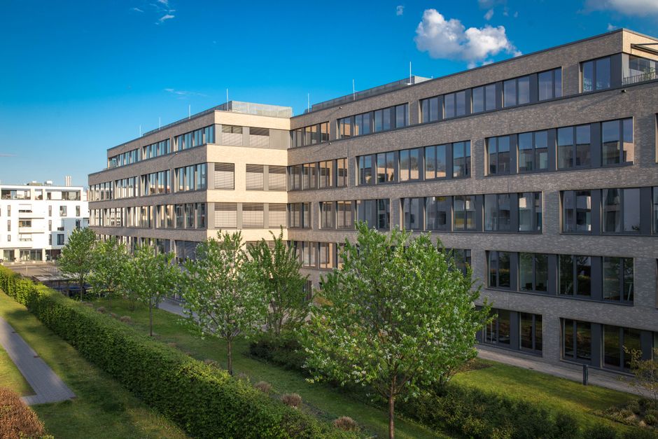 Exterior view of contemporary office buildings in Cologne, Germany, under a clear blue sky.