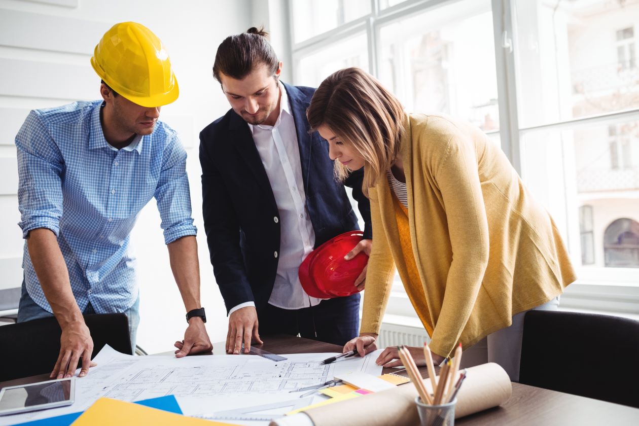 Three developers leaning over facility layout