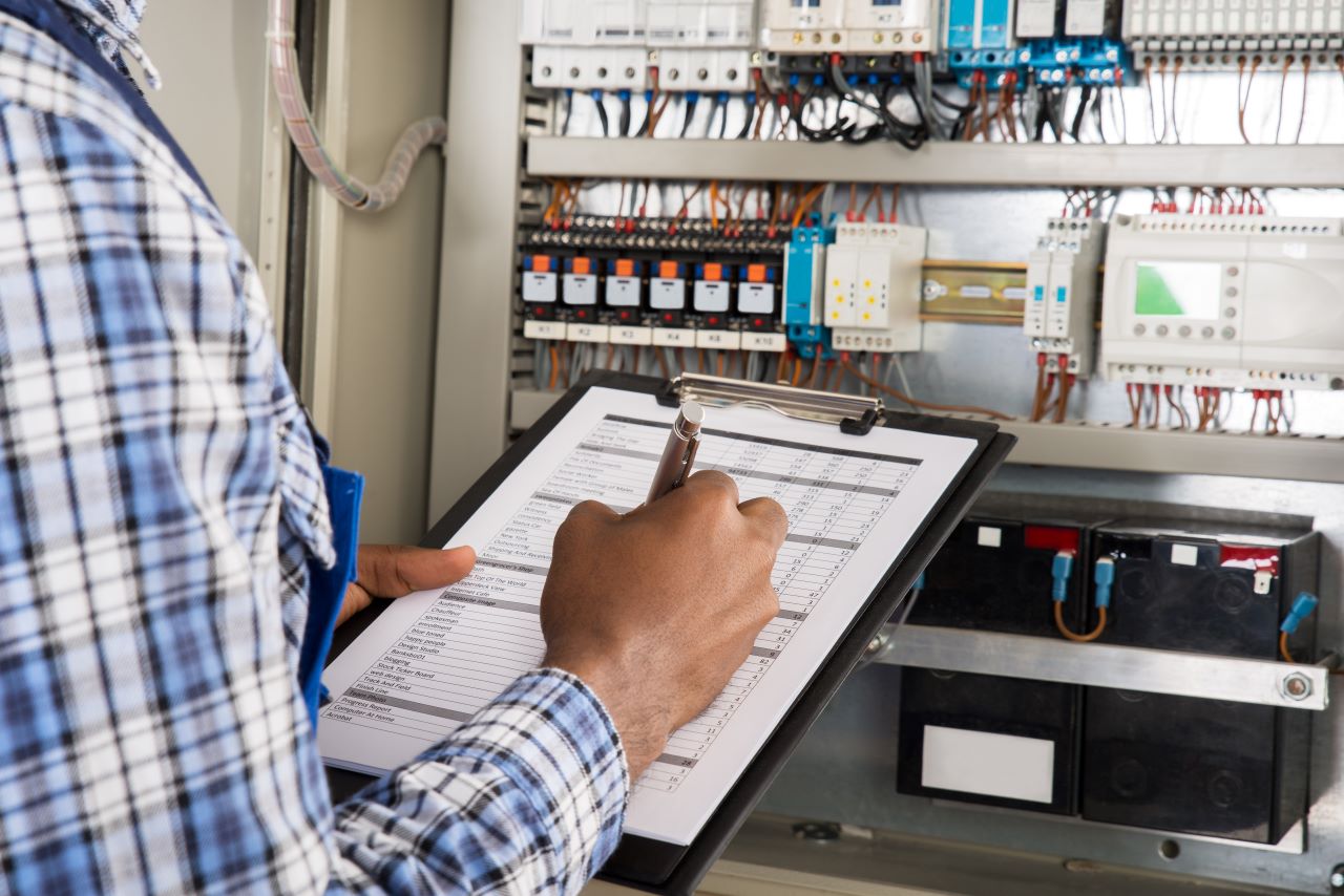 Man holding a clipboard while looking at controls