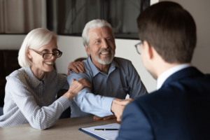 man and woman shaking hands with attorney after signing legal document