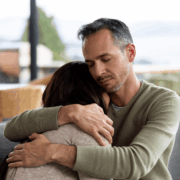 man comforting a grieving woman