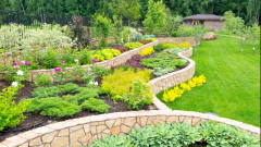 Natural stone landscaping in home garden with multiple levels of beds and walls