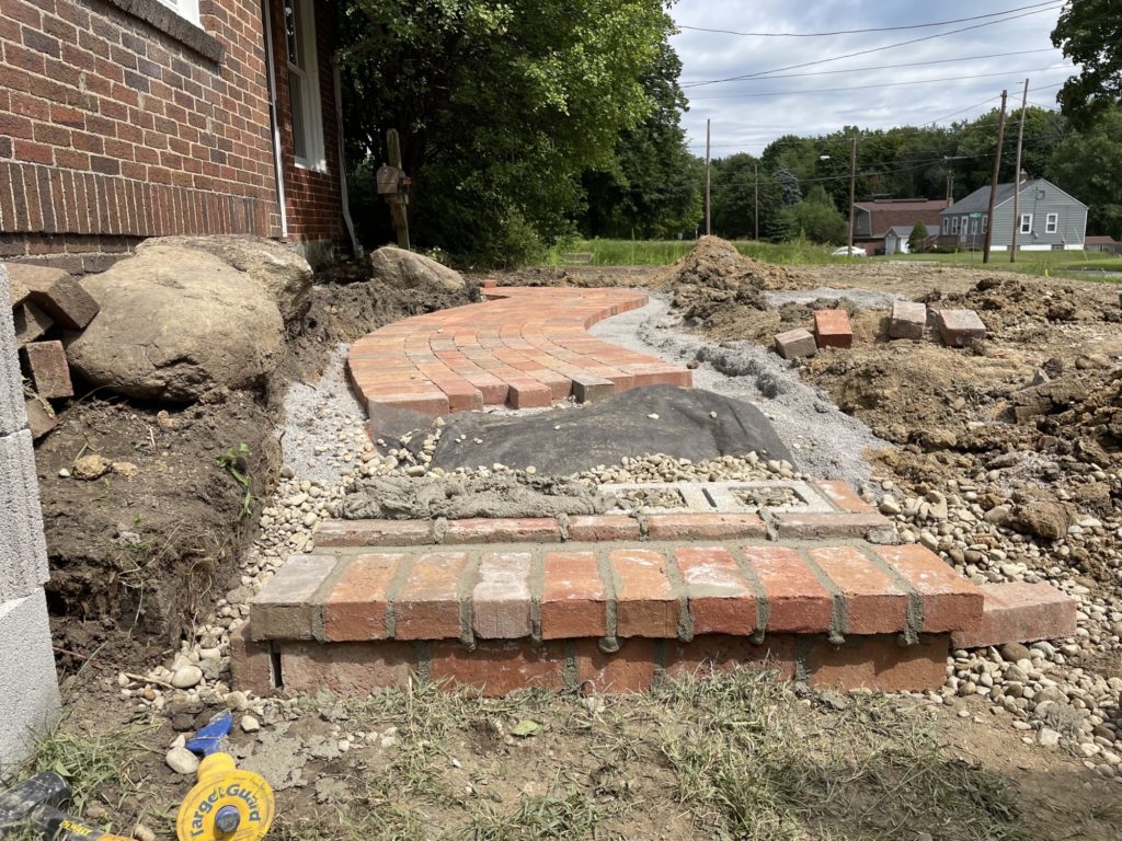 installation of red brick walkway on a residential property