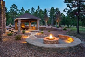 Residential landscape featuring firepit, fireplace, and stone pavilion