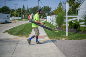 BruZiv worker with leaf blower cleaning up commercial property after landscaping maintenance