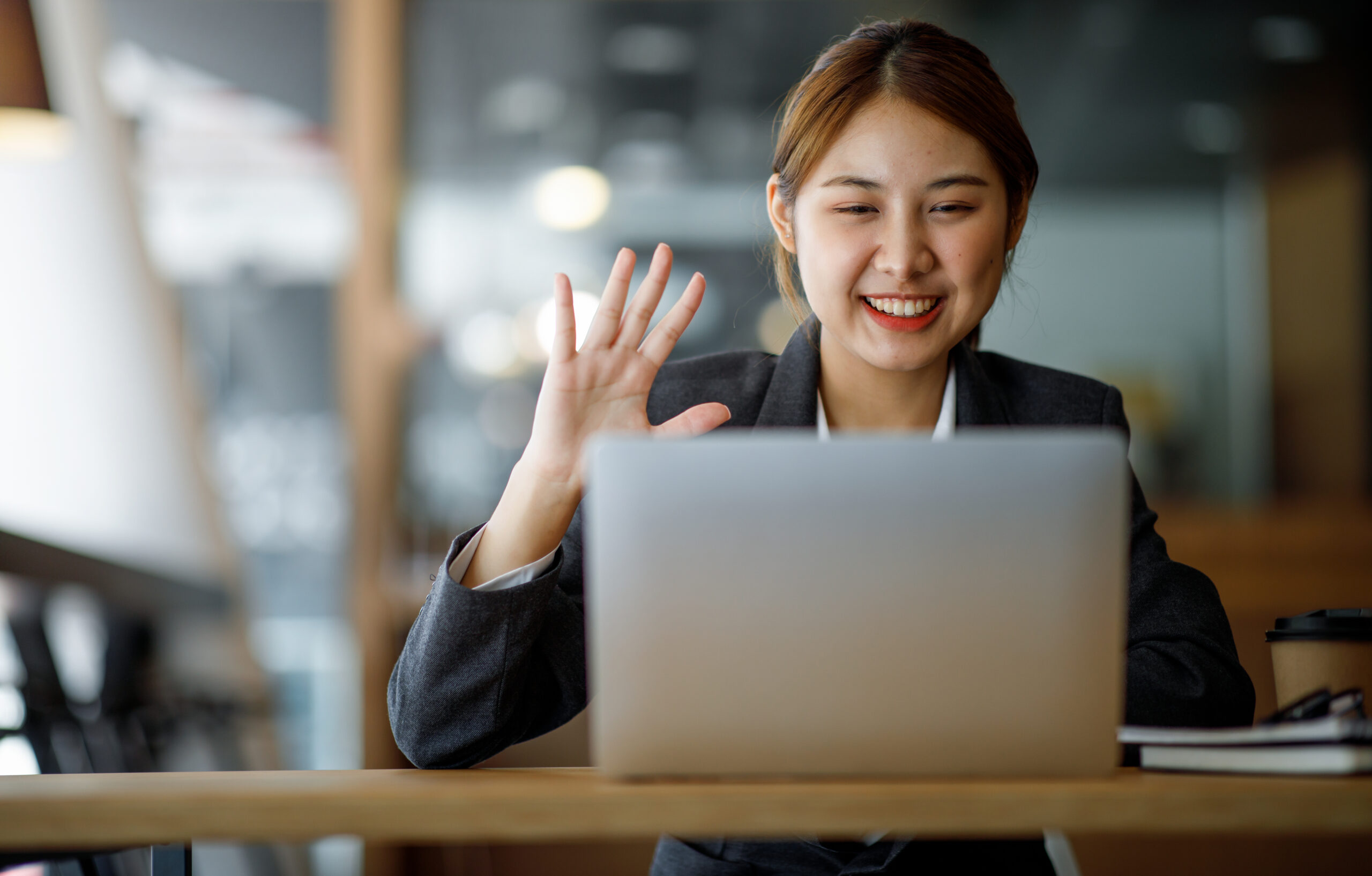 Shot of Asian young business woman looking and speaking through the webcam while making a video conference from the office.