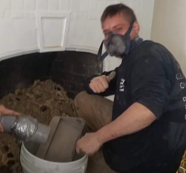 Century Chimney employee cleaning fireplace