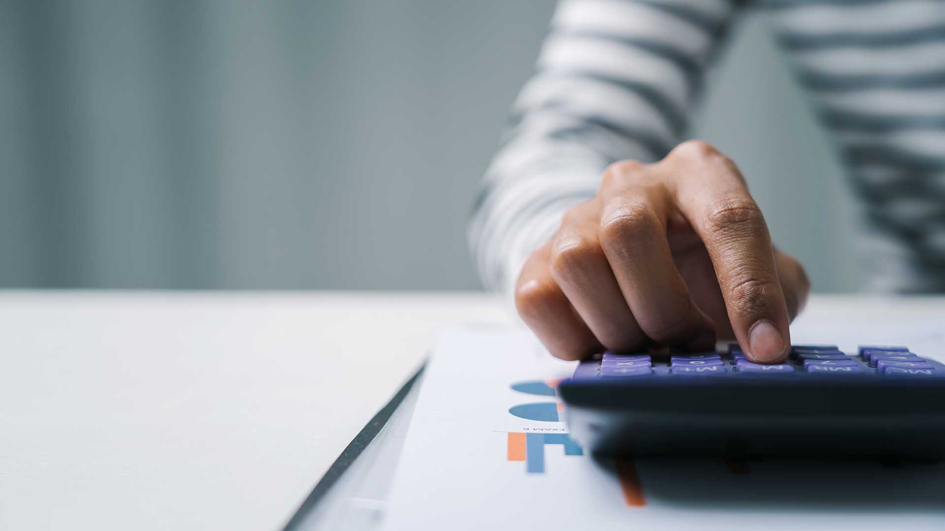 Close up business woman secretary using calculator to do math finance in office with tax accounting statistics research concept.