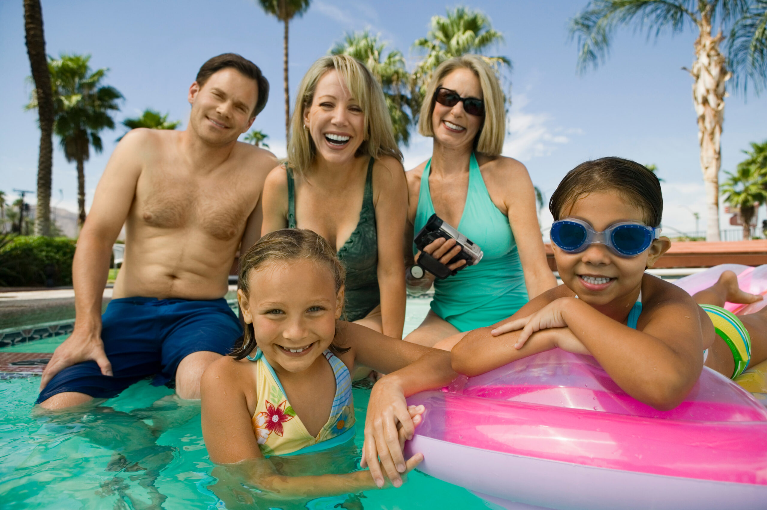 Portrait of smiling two girls with parents and grandmother in the swimming pool Family Vacation