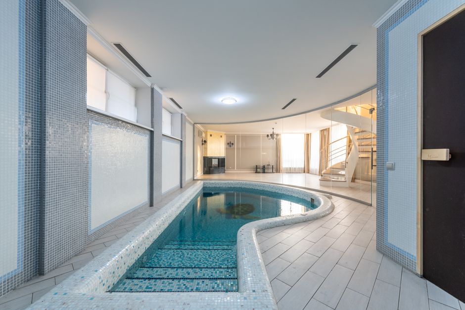 Small swimming pool in spa zone with tiled floor and walls of spacious villa on sunny day