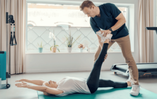 personal trainer stretching client after their workout
