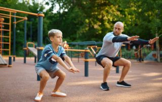 dad doing squats with his son for a workout