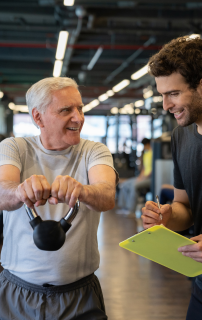 senior male working out with personal trainer to help combat osteoporosis