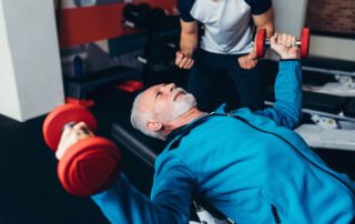 elder man working out with a personal trainer