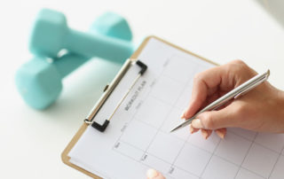 woman making a good workout plan on a clipboard