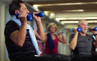 Senior men and women strength training by lifting weights