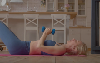 Women laying on floor using weights