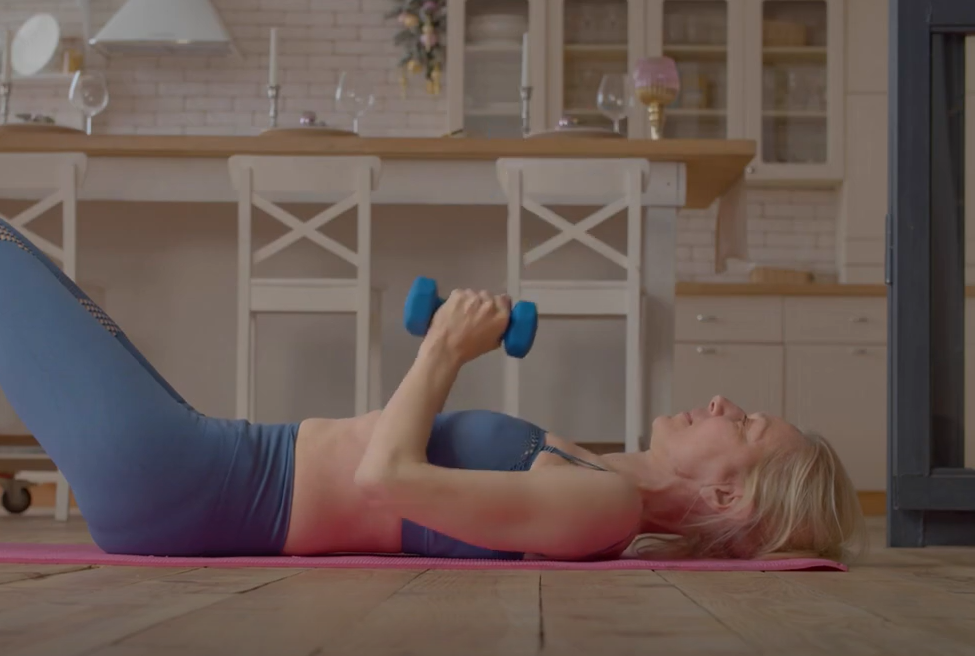 Women laying on floor using weights