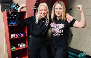 dr. meg kalsy and personal trainer lisa posing for a picture together flexing their arms