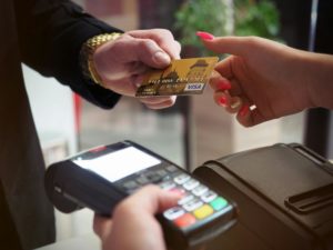 Someone paying with a card at a checkout counter