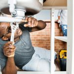 plumber fixing leaking pipe